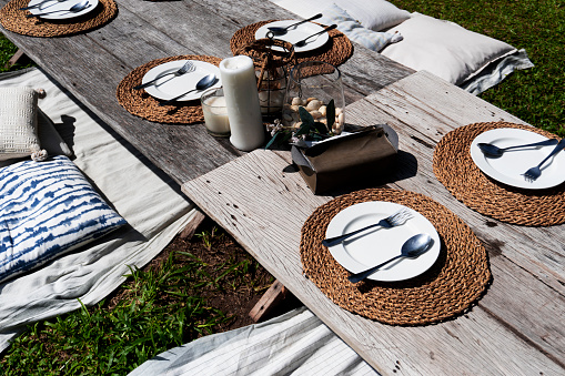 Close up to the picnic set-up out door on the family holiday with natural setting table with warm light color on the garden in summer day