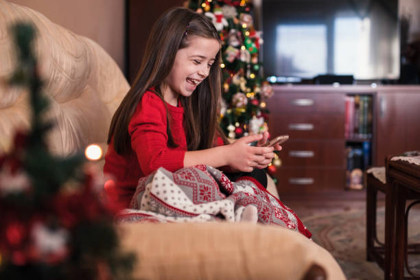 istock Girl laughing when using smart phone during New year at home 1292107482