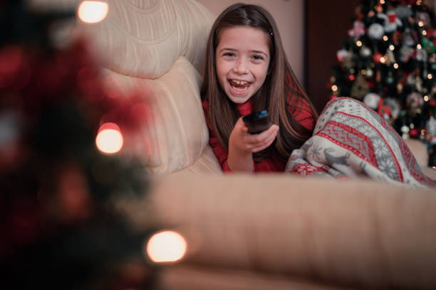 istock Girl laughing when holding remote control in her hand 1292107510