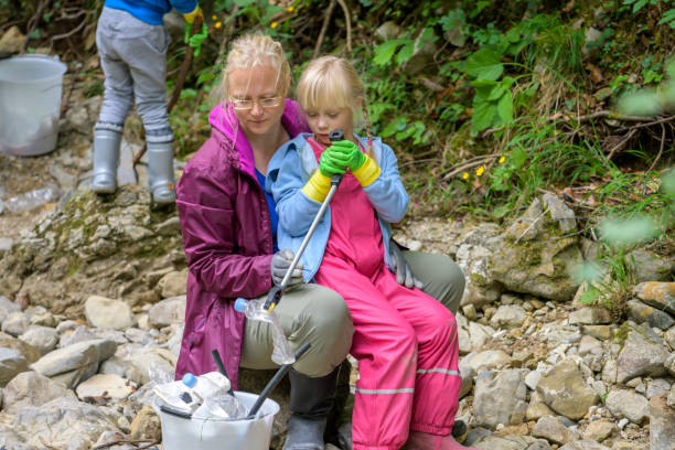istock School-age girl using garbage picker to collect rubbish 1292107524