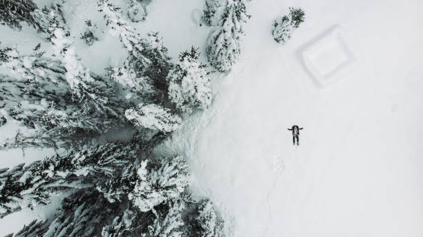 istock Drone view of a man making snow angel 1292108561