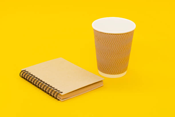 istock coffee cup and craft notebook on a yellow background. 1292114254
