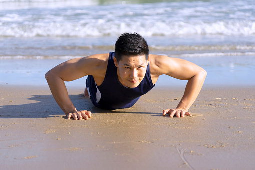 man exercise by Push up on the beach. Summer time and healthy lifestyle. Fun on the beach concept.
