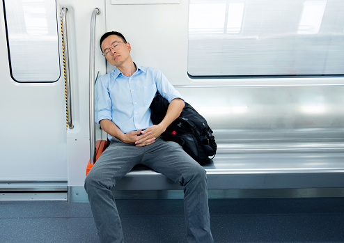 Tired businessman sleeping in subway train