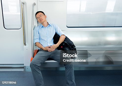 istock Tired businessman sleeping in subway train 1292118046
