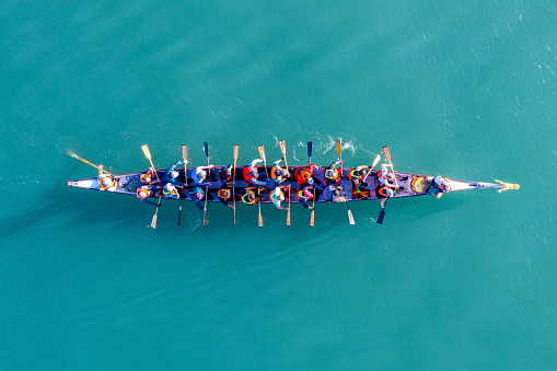 Haifa, Israel - December 11, 2020: Dragon Boat team rowing to the pace of an onboard Drummer, Aerial view.