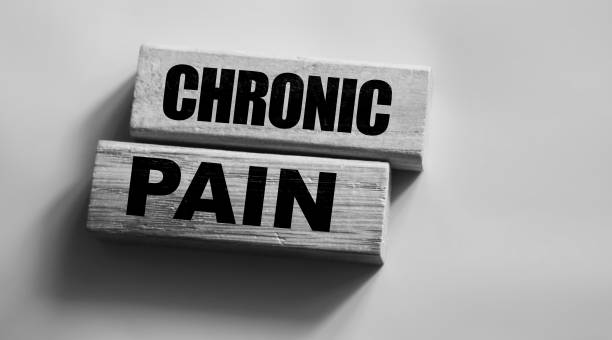 Chronic pain words on wooden blocks on pink with copyspace. Healthcare concept Chronic pain words on wooden blocks on pink with copyspace. Medicine healthcare concept. chronic illness photos stock pictures, royalty-free photos & images