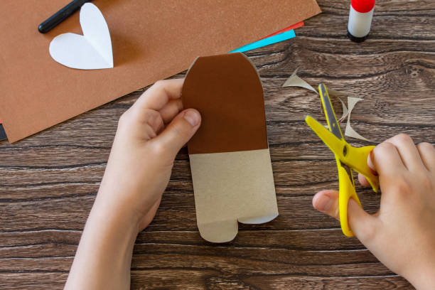 istock Instruction, step 6. On Mothers Day or Valentines Day gift - a teddy bear with a heart-card. Handmade paper ideas. Childrens creativity project, handmade, crafts for kids. 1292121735