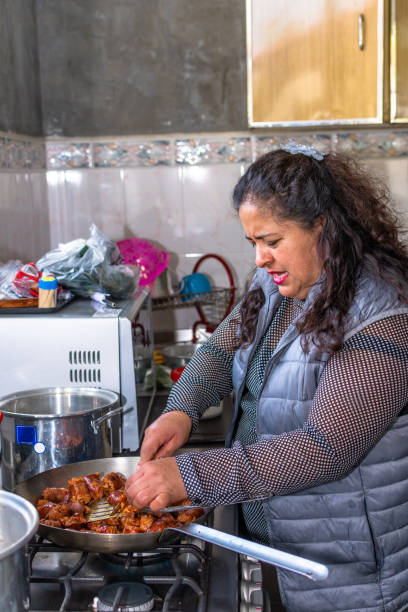 istock woman cooking meat in her kitchen 1292122749