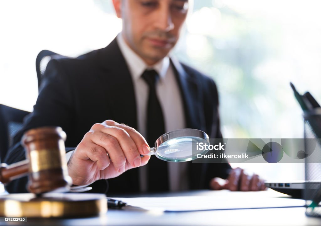Man In Black Suit Reading A Legal Document Carefully Using Magnifying Glass Conformity Stock Photo