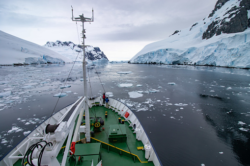 A passenger ship passes the Lemaire Channel. View of the ship's bow. Antarctica.