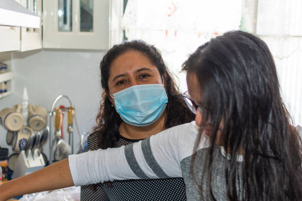 istock woman and her daughter using mask cooking meat in her kitchen 1292123121