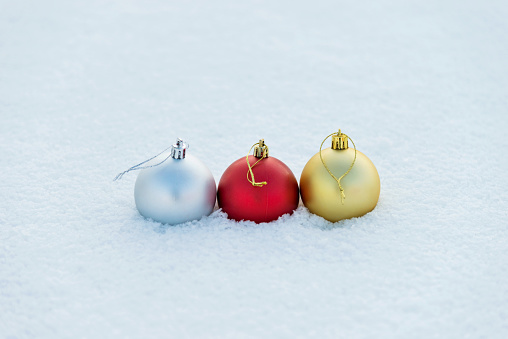 Three Christmas balls on the snow.
