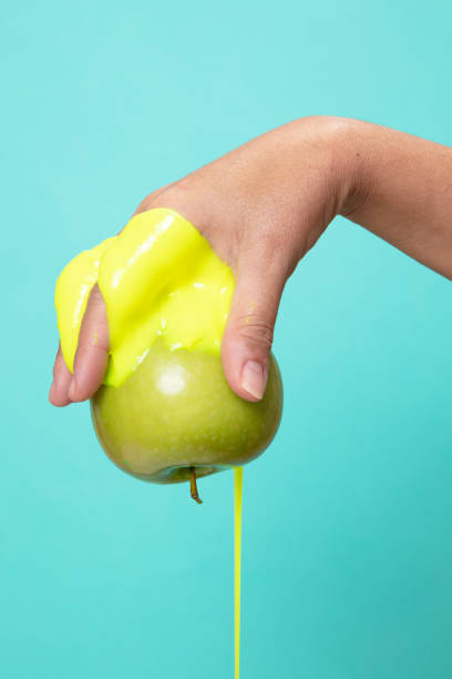 istock Hand Holding Sliced green Apple on green paper background. 1292125259