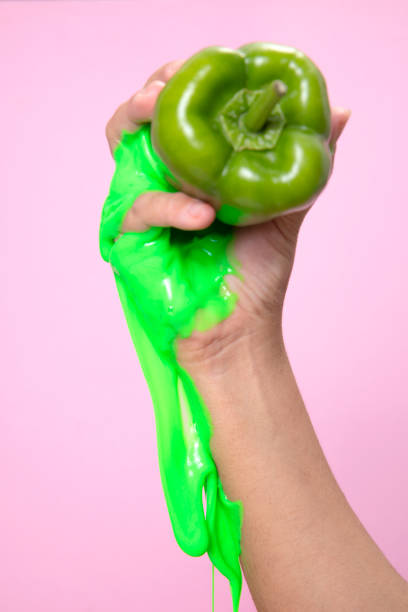 istock Hand Holding Sliced green Bell pepper on pink paper background. 1292125612