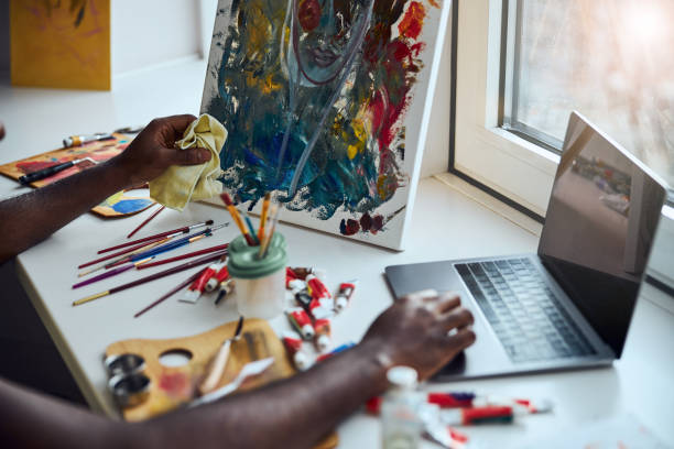 Adult man moving the cursor with a touchpad while finishing the cleaning of a painting