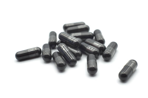 istock black capsules of coal on white background 1292132770