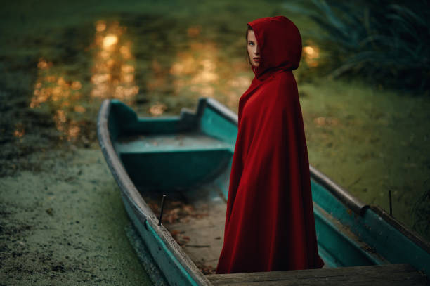 not so Little Red Riding Hood lost in the forest, standing in front of a small pond - shoot with a tilt shift lens