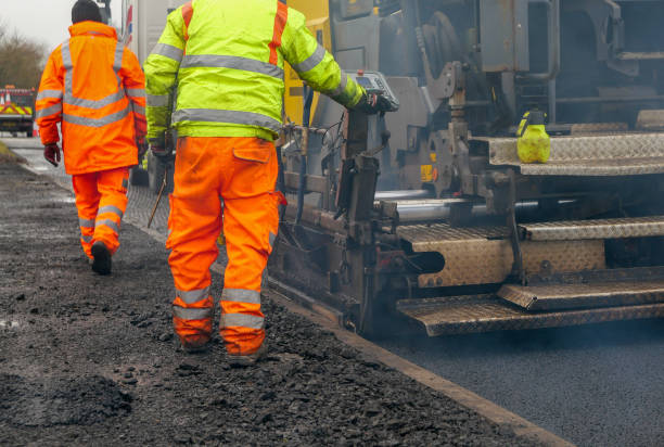 istock Two construction workers carrying our roadworks laying new asphalt 1292138922