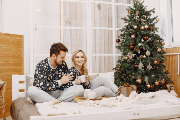 istock Cute couple at home near christmas tree 1292139053
