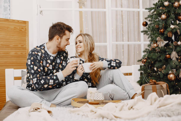 istock Cute couple at home near christmas tree 1292139062