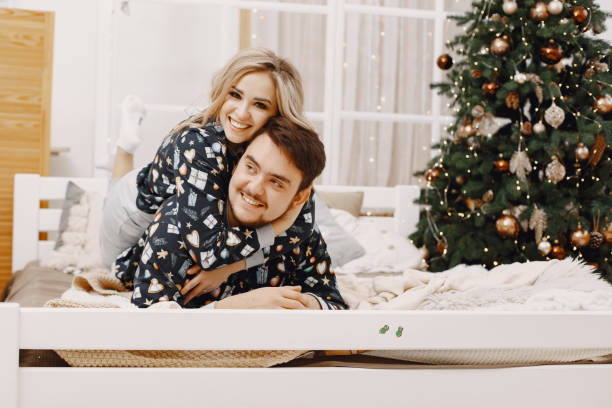 istock Cute couple at home near christmas tree 1292139103