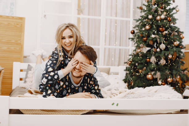 istock Cute couple at home near christmas tree 1292139108