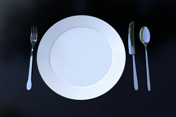istock Empty porcelein plate ready to serve with fork, knife, and spoon on a table. 1292140368