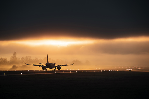 Airplane landing on a foggy morning