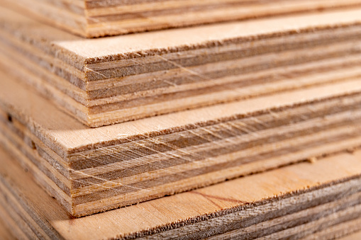 Paneles de madera contrachapada apilados uno encima del otro. Materiales para carpinteros para la construcción de muebles. Fondo oscuro. photo