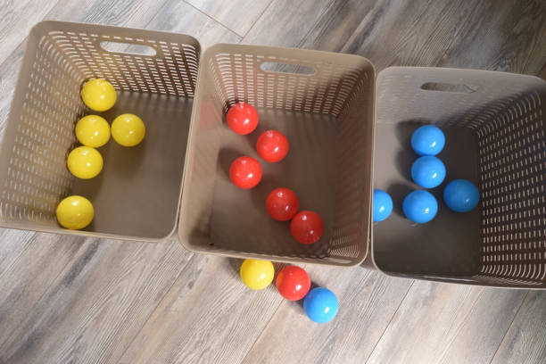 primary colored plastic balls sorted into colors in bins - primary colours imagens e fotografias de stock