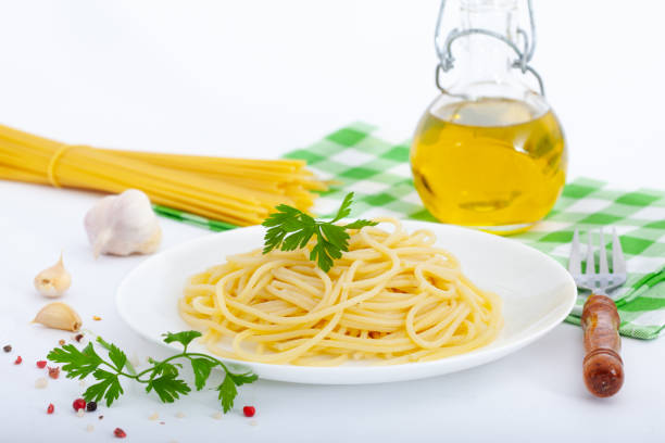 Simple italian spaghetti with olive oil and spices on white background. Healthy vegetarian pasta food.