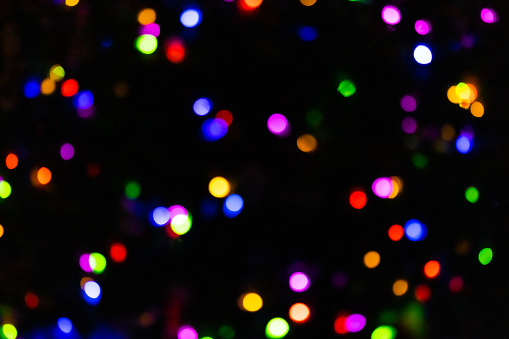 Small multicolored lights in a blurry bokeh background with copy space