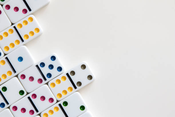 istock Colorful dominoes arranged on white background with negative space for copy 1292156450