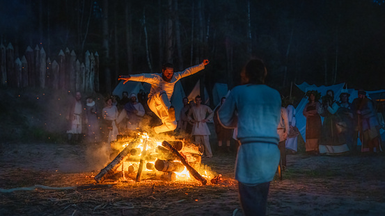 Cedynia, Poland, June 2019 Pagan reenactment of Kupala Night, called in Poland Noc Kupaly, man showing his bravery is jumping over bonfire. Slavic holiday celebrated on the shortest night of the year
