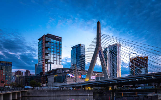 Boston Skyline with Zakim Bridge at Twilight The twilight landscape of the Leonard Zakim Bridge over the interstate I-93 standing tall over the Boston Skyline boston massachusetts photos stock pictures, royalty-free photos & images