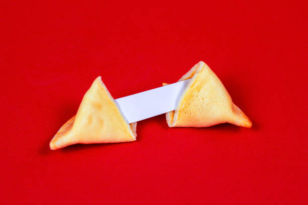 istock Fresh baked yellow Chinese fortune cookies with white blank note inside on red background 1292168887