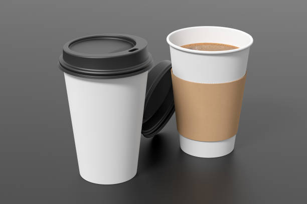 istock Two white take away coffee paper cups mock up with black lids on black background. Opened (with holder) and closed disposable cups. 1292171172