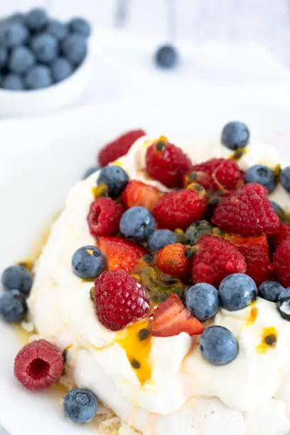Photo of Pavlova with strawberries, blueberries, raspberries and passionfruit