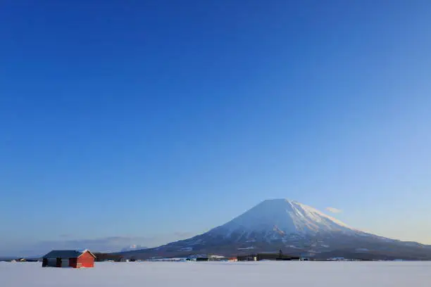 I saw a red farmhouse and Mount Yotei in Niseko, Japan.