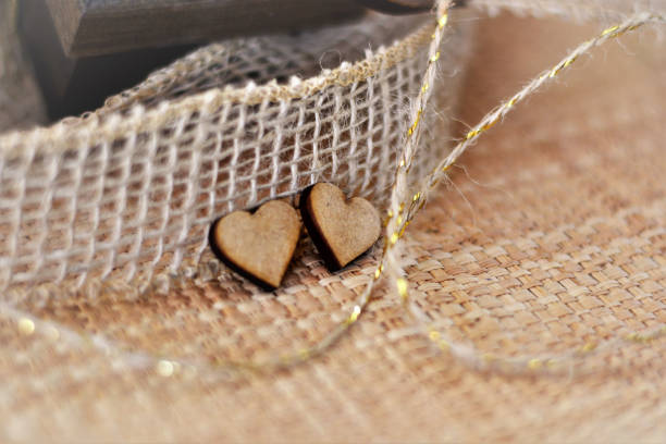 Two wooden hearts on ribbon and jute line