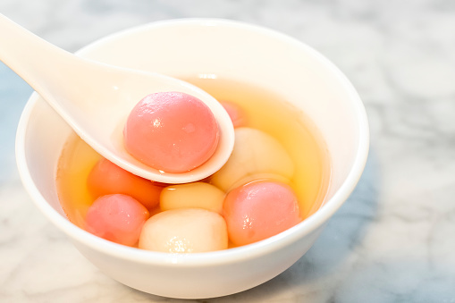 Close-up of a bowl of mix colors Chinese Tang Yuan dessert served on white porcelain bowl on of Chinese New Year