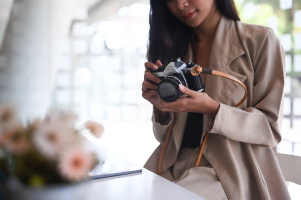 istock Beautiful female photographer checking photos in camera while sitting at her studio. 1292186713