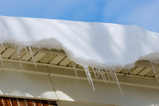 Dangerous icicles in a building house roof