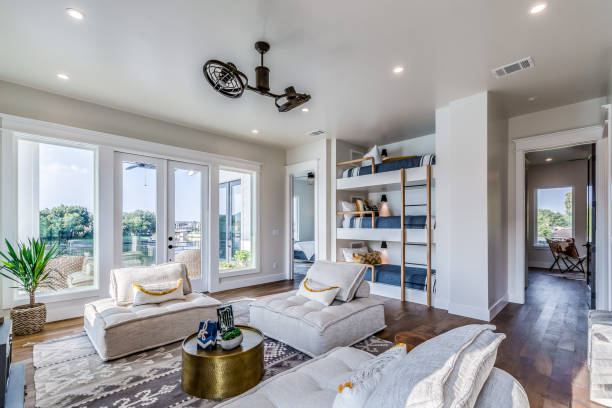 Very cool family room with comfy chairs and triple bunk beds Unique ceiling fan and chairs make this common room a place to hang out villa stock pictures, royalty-free photos & images