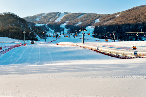 Empty ski slope under blue sky.