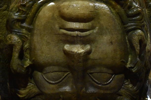 A massive head of Greek mythological figure Medusa supports a large column in the Basilica Cistern, Istanbul, Turkey