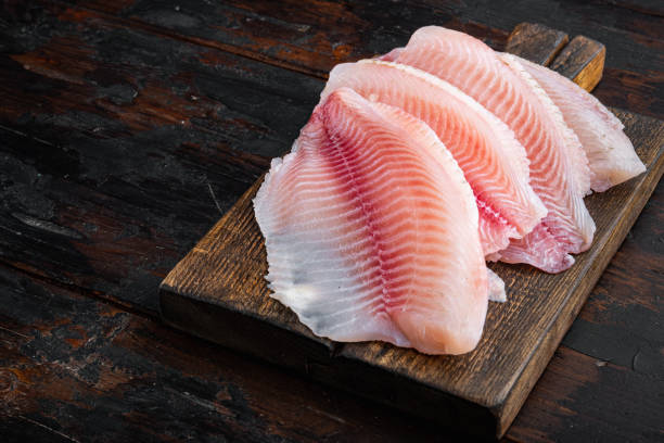 istock White tilapia fish fillet, on dark wooden background 1292205322
