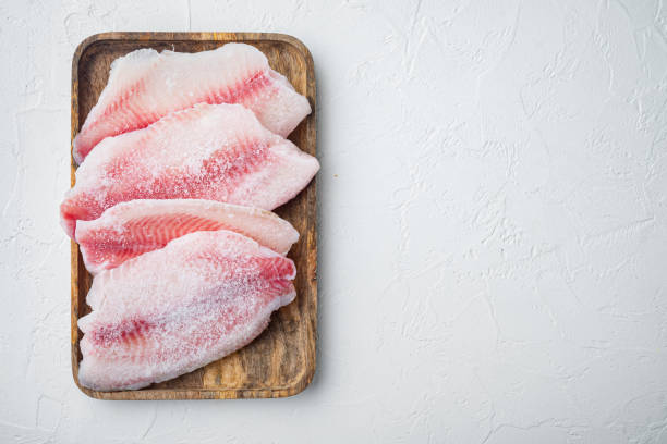 冷凍白身魚フィレット、白い背景、テキスト用のコピースペース付きトップビュー - prepared fish tilapia fillet seafood ストックフォトと画像
