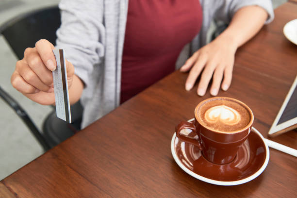 istock Woman paying for cup of coffee 1292206493